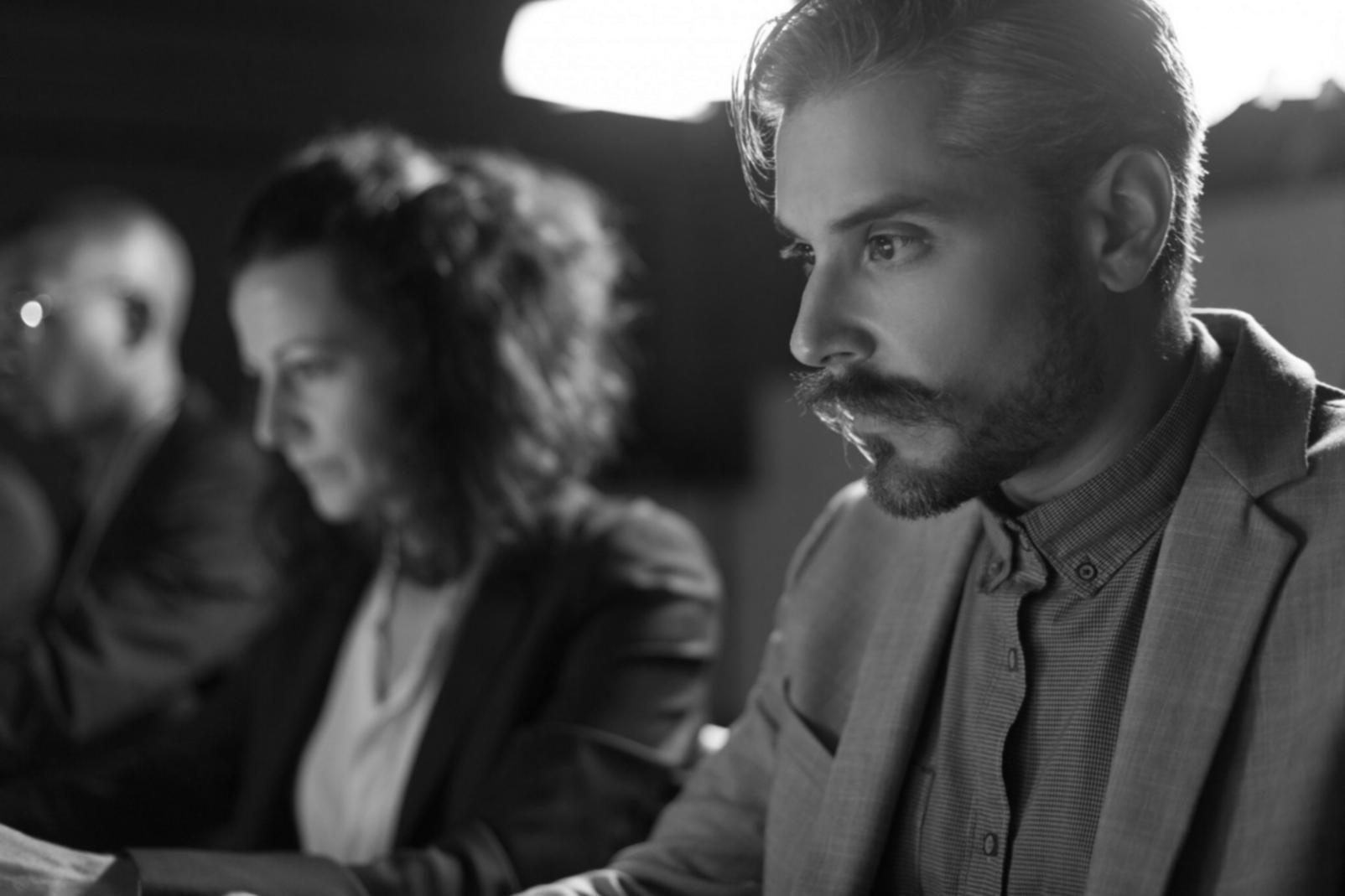 Analist lucrând la modelare financiară complexă pe ecrane multiple